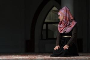 joven musulmana rezando en la mezquita foto