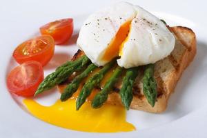 Toast with asparagus, poached egg and tomato closeup