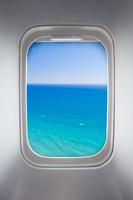 side window of airplane with sea view photo