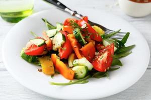 Ensalada fresca con tomates, pepinos y rúcula foto