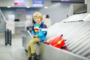 little tired kid boy at the airport, traveling photo