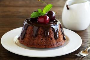 pastel de chocolate con glaseado y una cereza. foto