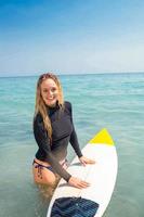 mujer con una tabla de surf en el océano foto