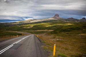carretera a través del paisaje de las montañas de islandia foto
