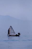 pescador en el lago Inle trabajando en un pie