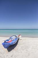 kayak azul descansando sobre arena blanca del caribe