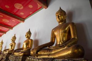 fila de budas en el templo en bangkok foto