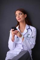 joven doctora sentada en el suelo con su teléfono