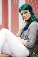 Portrait of young beautiful woman with a mask outdoors photo