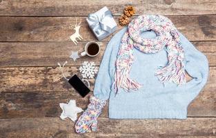 Winter clothes on wooden background.