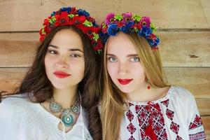 Two young beautiful  girls with long hair in Ukrainian blouses