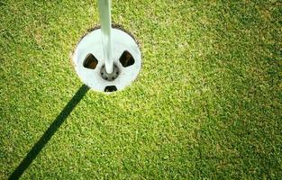 Golf cup on green background with copyspace