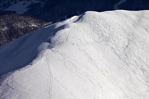 Top view on off piste slope with snowboarders and skiers photo
