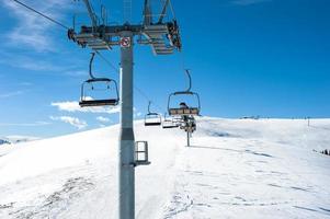 Chairlift on ski slope in mountain resort photo