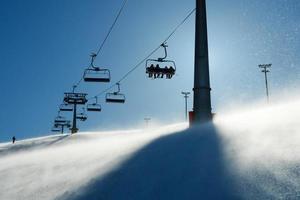 backlit scenes with ski lift chairs photo
