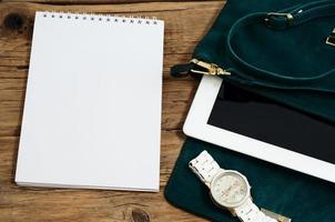 cuaderno con bolso femenino, tableta y relojes foto