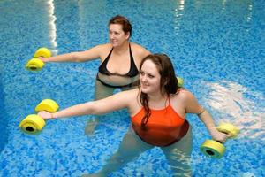 Two fat  women in water on training photo