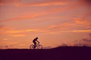 hombre con amanecer en bicicleta de montaña