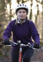 Mujer montando bicicleta de montaña a través de bosques foto