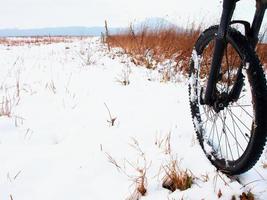 The front wheel of mountain bike in the first snow.
