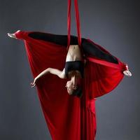 Graceful dancer on aerial silks posing upside down photo