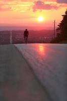 Cyclist riding on the road during sunset