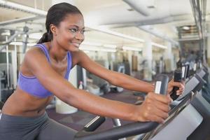 Fit woman working out on the exercise bike photo