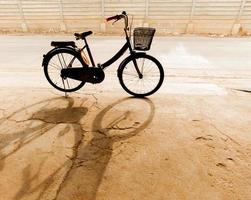 Bicycle standing in the parking lot and its shadow photo