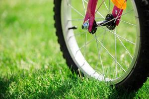 Children's bicycle on green grass, close up photo