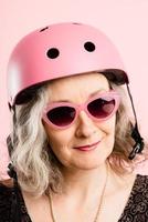 Mujer divertida con casco de ciclismo retrato fondo rosa real foto