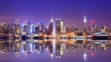 Water view of the Manhattan skyline at dusk with reflection photo