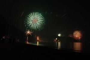 hermosos fuegos artificiales celebrando año nuevo en la playa