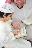 padre e hijo árabe musulmán recitando el Corán foto