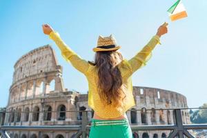 Woman with italian flag rejoicing near colosseum in rome, italy