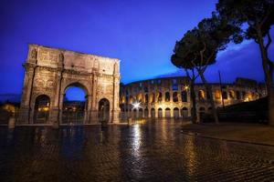 Coliseo y arco de Constantino en la noche foto