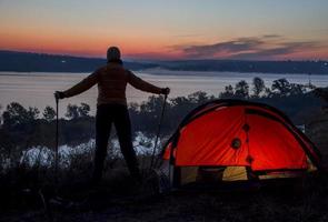 Hiker, tent and sunrise photo