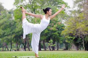 Beautiful woman practicing yoga in the park