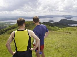 hombres en la colina mirando el lago