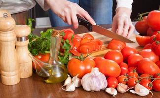 manos femeninas cortando tomates