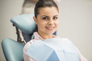 paciente morena sonriendo en odontología foto