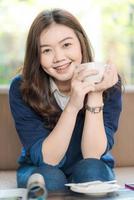 Happy asian smiling female student drinking coffee photo