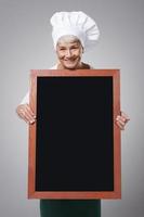 Female senior chef with menu photo