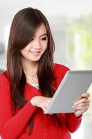 mujer joven en rojo con tablet PC foto