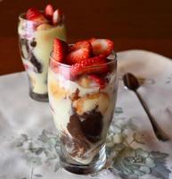 Vanilla mousse dessert with chocolate and cookies in glass