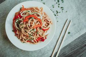 Bowl of chinese noodles with vegetables and shredded chicken photo