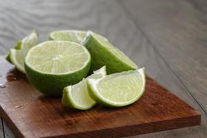 sliced limes on wooden board photo