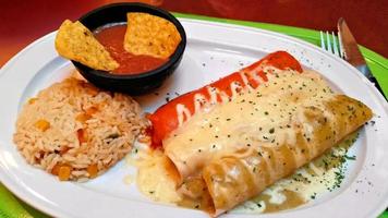 Red white and green enchiladas with rice and beans
