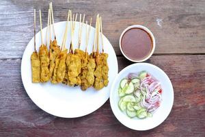 Pork Satay with Peanut Sauce, Wood table background.View from above. photo