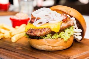 Pork burger with cheese, vegetable and served with fries photo