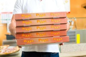 Delivery service - man holding pizza boxes photo